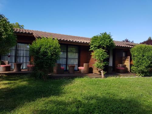 a house with trees and plants in a yard at Le Vieux Logis de Clam in Clam