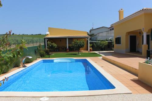 a swimming pool in the backyard of a house at Casa da Vinha Azeitão in Azeitao