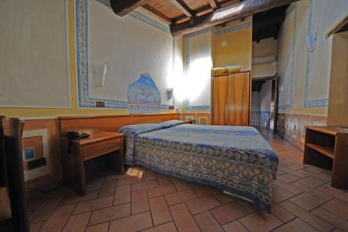 - une chambre avec un lit et une table dans l'établissement Albergo Giulia Gonzaga, à Sabbioneta