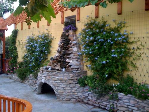 a stone fireplace in front of a building with flowers at Aegean Villas in Potos
