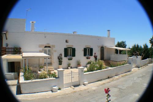 a white house with a fence in front of it at Casolare Capitolo in Cisternino