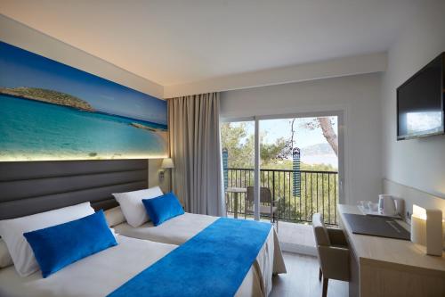 a hotel room with a bed and a balcony at Invisa Hotel Club Cala Blanca in Es Figueral Beach