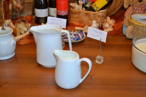 two white coffee mugs sitting on a wooden table at Häuslerhof in Maranza