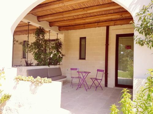 a patio with purple chairs and a table at Le Scuderie - Castello Monaci in Salice Salentino