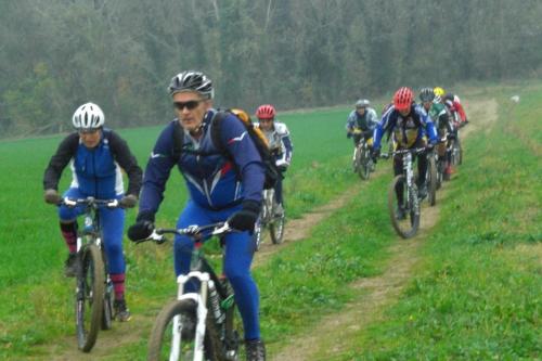 un grupo de personas montando bicicletas por un camino de tierra en Fondo Riso en Faenza
