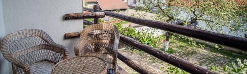 a pair of chairs sitting on a balcony at Casa Mosului - Transfăgărășan Bed & Breakfast in Cîrţişoara
