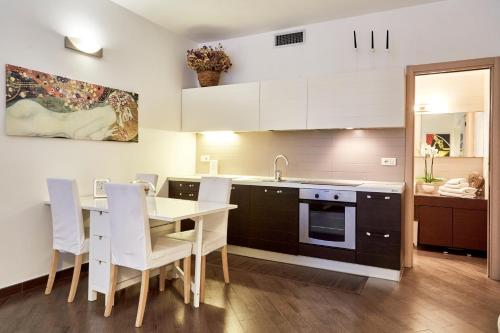 a kitchen with white cabinets and a table and chairs at Il Gioiellino in Sorrento