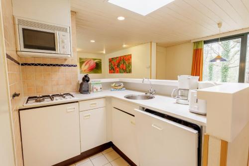 a kitchen with a sink and a microwave at Center Parcs Bispinger Lüneburger Heide in Bispingen