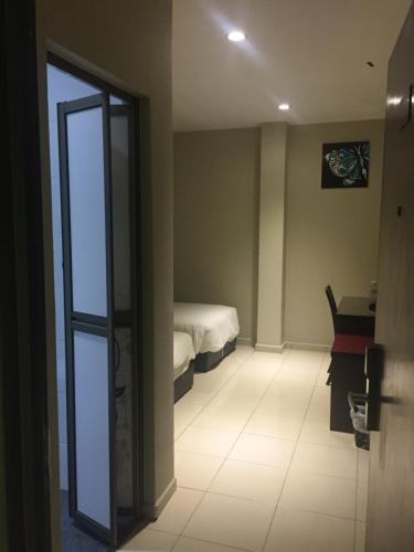 a room with a bedroom with a bed and a door at Ayer Hitam Hotel in Simpang Renggam