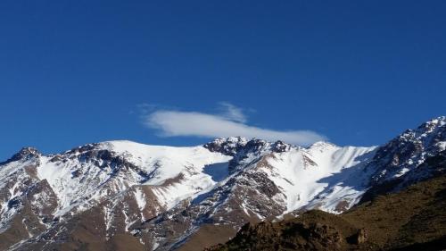 a snow covered mountain with a blue sky at Dar Amadine in Imlil