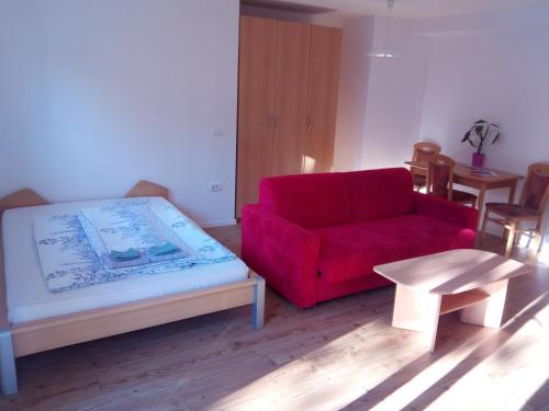 a living room with a red couch and a table at Apartments Pronavtik in Piran