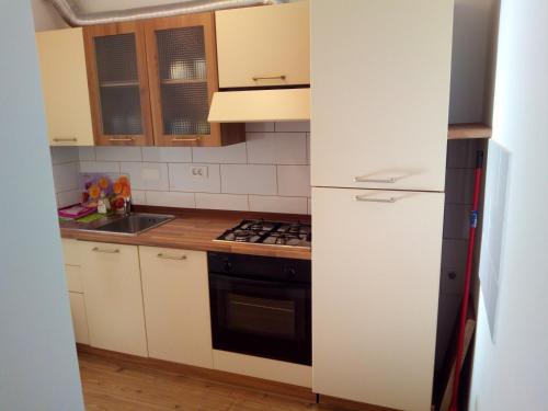 a kitchen with white cabinets and a stove top oven at Apartments Pronavtik in Piran
