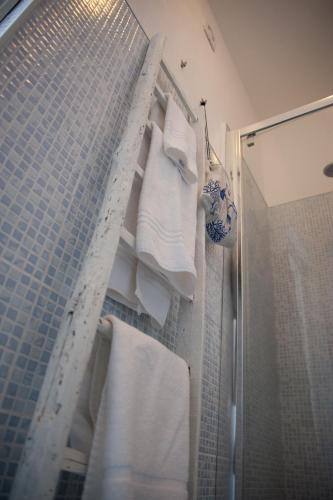 a bathroom with white towels and a shower at Sottovento Marzamemi Rooms&Relax in Marzamemi
