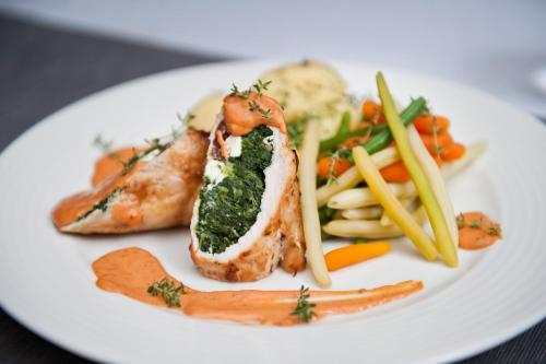 a white plate of food with meat and vegetables at Eurohotel Swarzędz in Swarzędz
