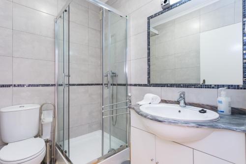 a bathroom with a toilet and a sink and a shower at Apartamento Arenga in Lagos