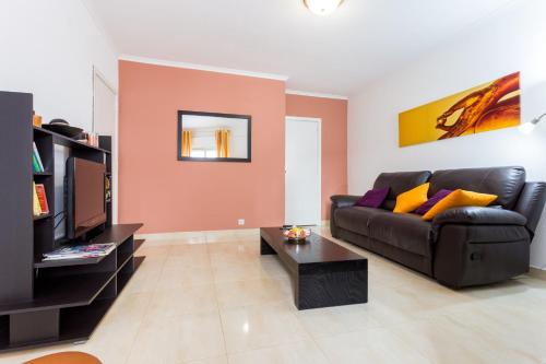 a living room with a couch and a tv at Apartamento Arenga in Lagos