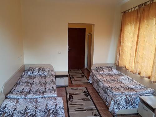 a room with three beds in a room at Hotel Fantasy in Lyubimets