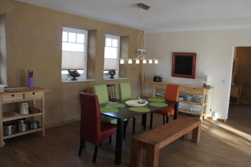 a dining room with a table and some chairs at Gut Settin am See - Ferienhäuser in Settin