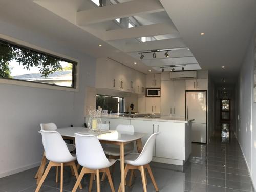 a kitchen with a wooden table and white chairs at Shellys Place in Rosebud