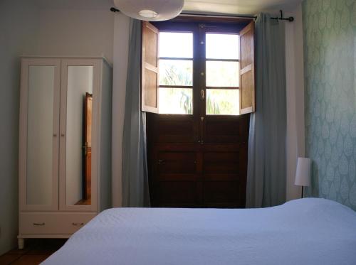 a bedroom with a bed and a window and a door at Casa Creativa in Hermigua