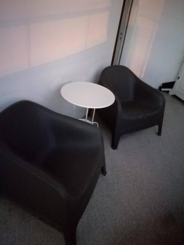 two black chairs and a white table in a room at Apartamento Trav. Santa Luzia in Mirandela