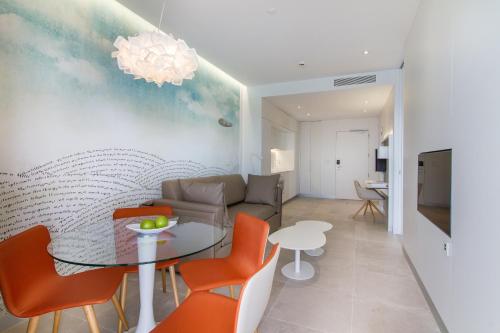 a living room with a table and orange chairs at ESTIMAR Calpe Suitopia in Calpe