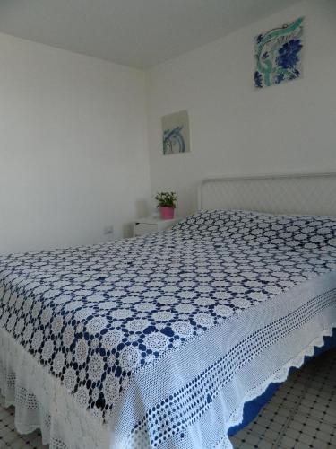 a bedroom with a bed with a blue and white bedspread at Il Nido del Gabbiano in Vietri sul Mare