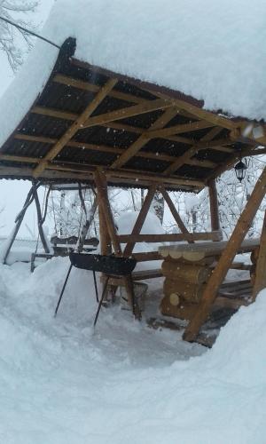 a wooden picnic table with snow on top of it at Dacha PODOBOVETS 127 in Podobovets