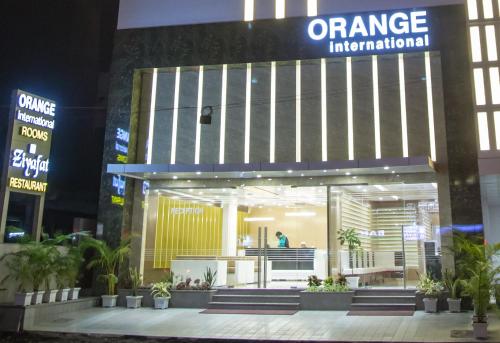 an entrance to an orange international building at night at Hotel Orange International in Surat