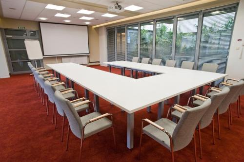 a conference room with a large white table and chairs at Eurohotel Swarzędz in Swarzędz