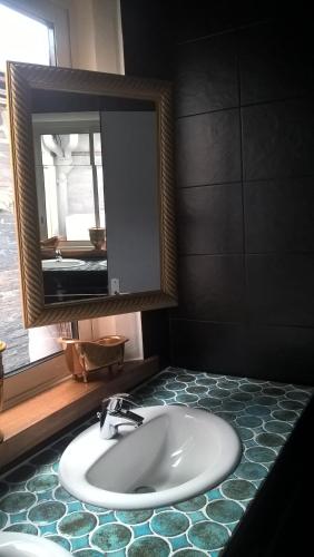 une salle de bain avec un lavabo et un miroir dans l'établissement Cote jardin, à Hontanx