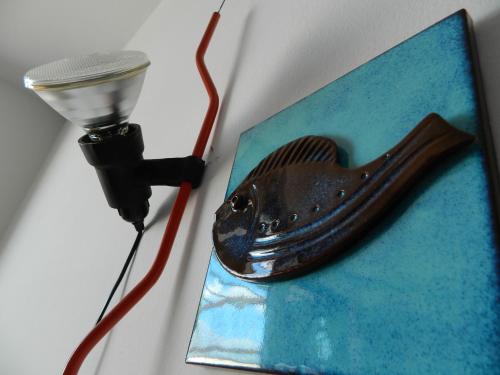 a light on a table with a fish shaped object at Il Nido del Gabbiano in Vietri sul Mare