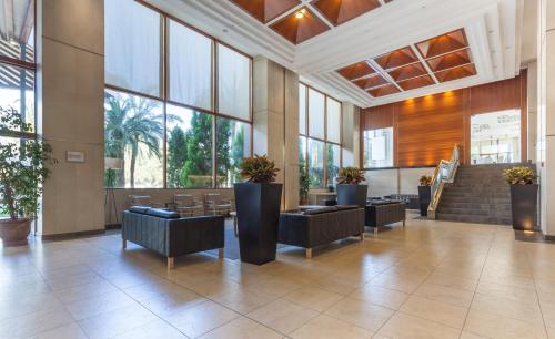 a lobby with chairs and plants in a building at Intelier Orange in Benicàssim