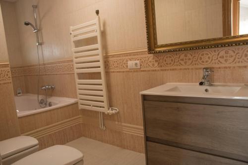 W łazience znajduje się toaleta, umywalka i lustro. w obiekcie Vut Duplex La Puebla Parking gratis w mieście Burgos