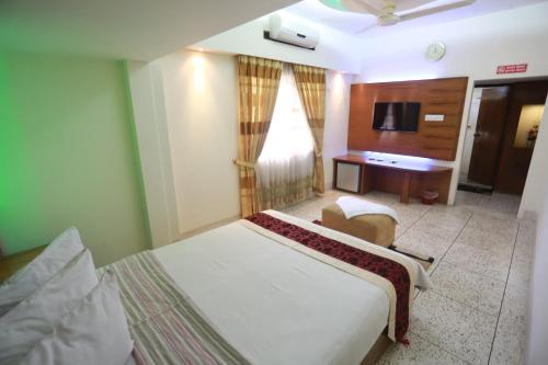 a hotel room with a bed and a television at Nagar Valley Hotel Ltd. in Dhaka