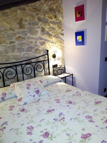 a bed in a room with a stone wall at La caseta de Pedris in Valderrobres