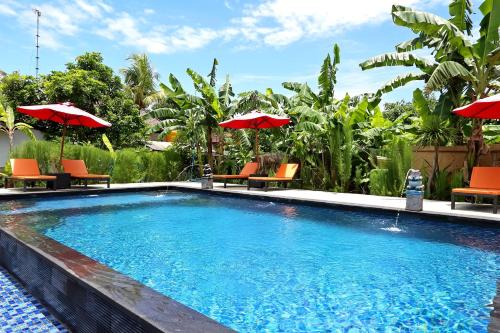 a swimming pool with orange chairs and umbrellas at Naradas Mushroom Beach in Nusa Lembongan