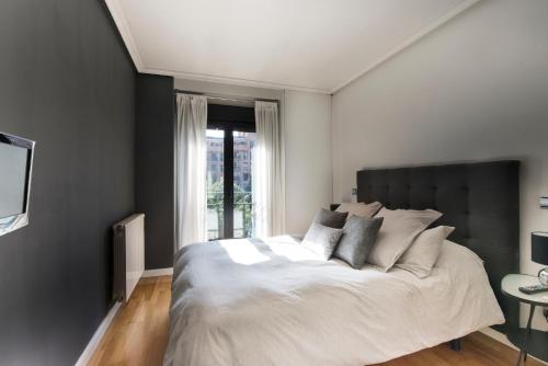 sypialnia z dużym łóżkiem i oknem w obiekcie Premium luxury city center apartment w Madrycie