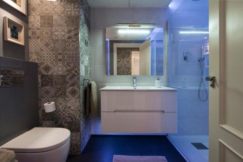 a bathroom with a toilet and a sink and a mirror at Premium luxury city center apartment in Madrid