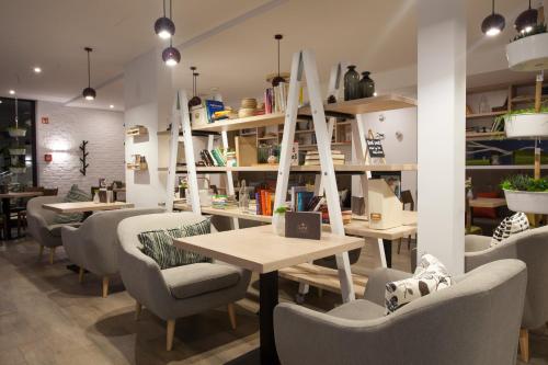 a restaurant with tables and chairs and shelves at Glamping Olimia Adria village in Podčetrtek