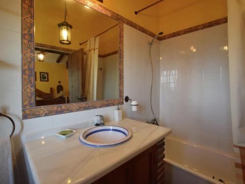 ein Badezimmer mit einem Waschbecken, einem Spiegel und einer Badewanne in der Unterkunft Belvilla by OYO Casa AragÃ¼ez in Canillas de Aceituno
