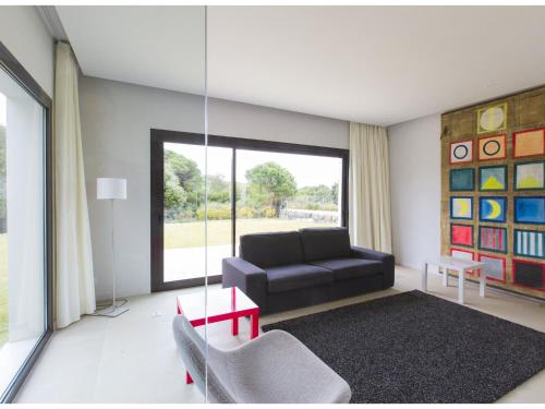 - un salon avec un canapé noir et une balançoire dans l'établissement Elegant Villa by the Coast, à Sant Andreu de Llavaneres