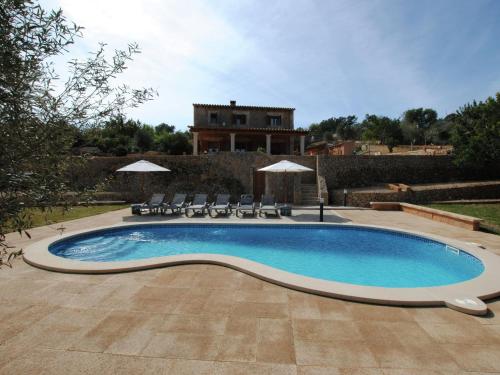 una piscina con sedie e una casa sullo sfondo di Belvilla by OYO Es Rafal a Marratxi