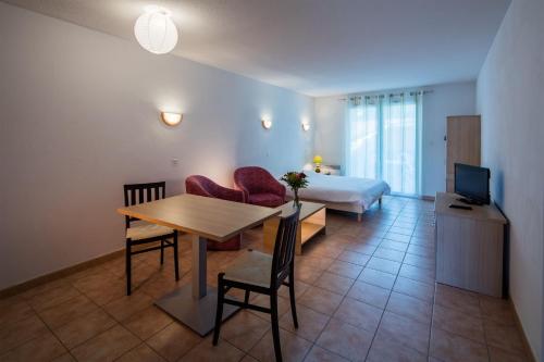 - une chambre avec une table et un lit dans l'établissement Vacancéole - Le Domaine du Golf d'Albret, à Barbaste
