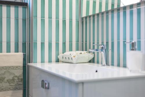a bathroom with green and white striped walls and a sink at Casa Rosanna in Maiori