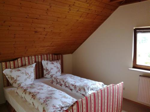 a bed in a room with a wooden ceiling at Alte Schreinerei-Auberge Harlekin in Singen