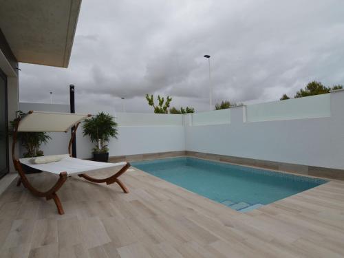 a room with a pool and a bench next to a building at Belvilla by OYO Casa del Ananas in San Pedro del Pinatar