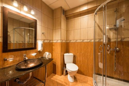 a bathroom with a toilet, sink, and shower at Avenue Hotel in Burgas City