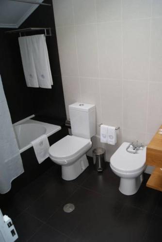 a bathroom with a white toilet and a sink at Casa do Comendador in São Roque do Pico