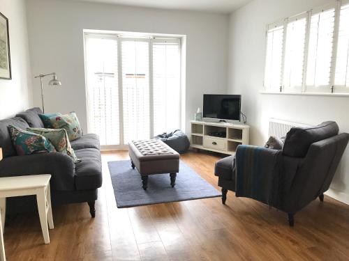 a living room with two couches and a tv at The Gallery Two Bedroom Apartment in Oakham